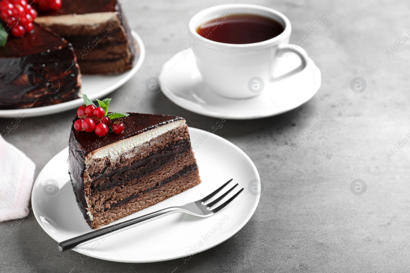 Photo of Tasty chocolate cake with berries on grey table