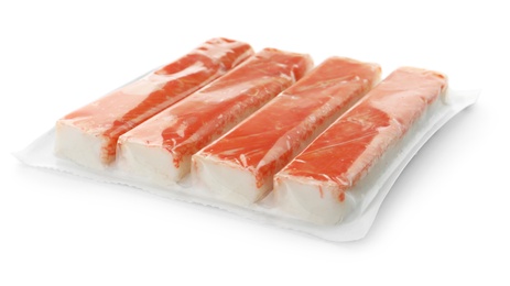 Photo of Delicious crab sticks in plastic packaging isolated on white