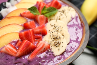 Delicious acai smoothie with fresh fruits in bowl, closeup