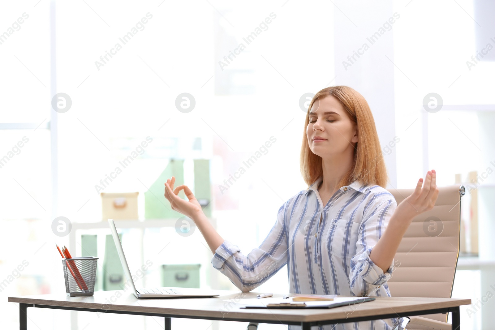 Photo of Beautiful woman meditating at table in office during break, space for text. Zen yoga