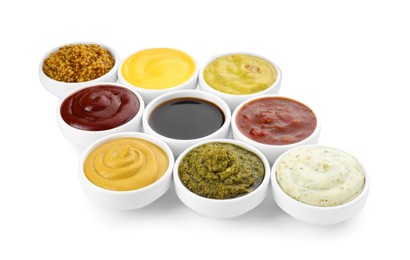 Many different sauces in bowls on white background