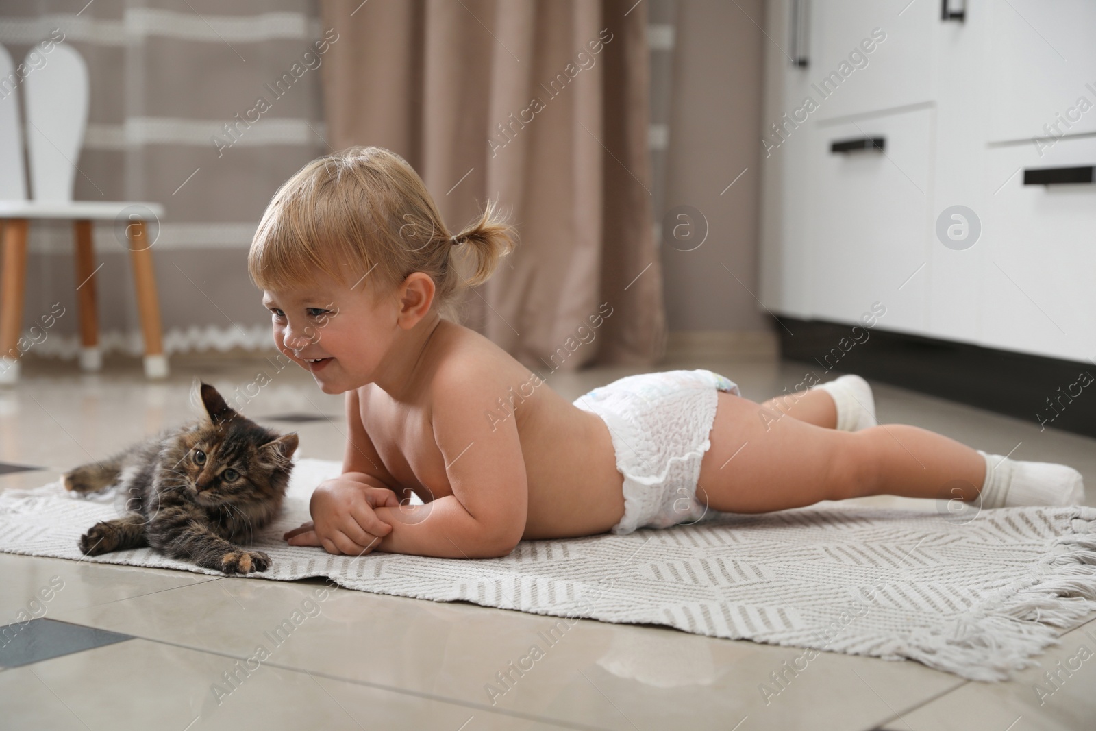 Photo of Cute little child with adorable pet on floor at home