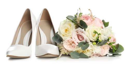 Photo of Pair of wedding high heel shoes and beautiful bouquet on white background