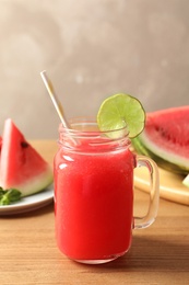 Photo of Summer watermelon drink in mason jar and sliced fruit on table