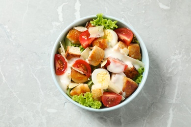 Photo of Delicious fresh Caesar salad on grey marble table, top view