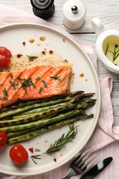 Photo of Tasty grilled salmon with tomatoes, asparagus and spices served on table, flat lay