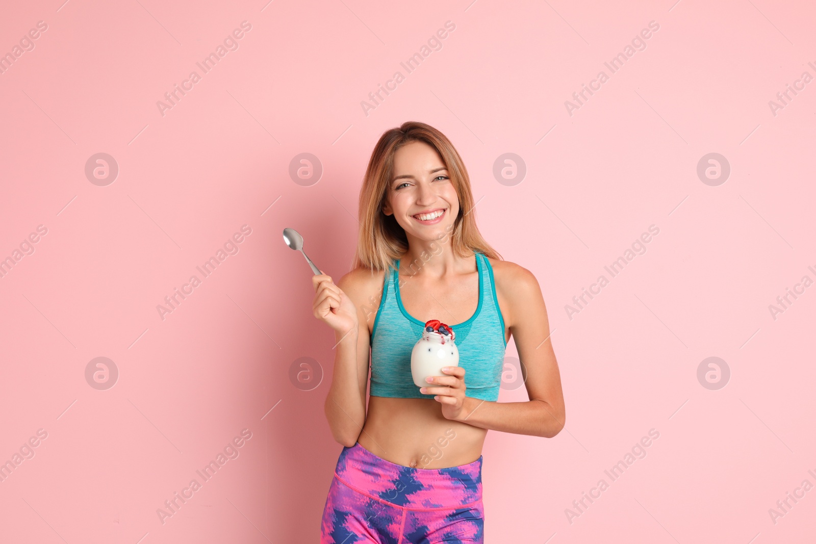 Photo of Happy slim woman in sportswear with yogurt on color background. Weight loss diet