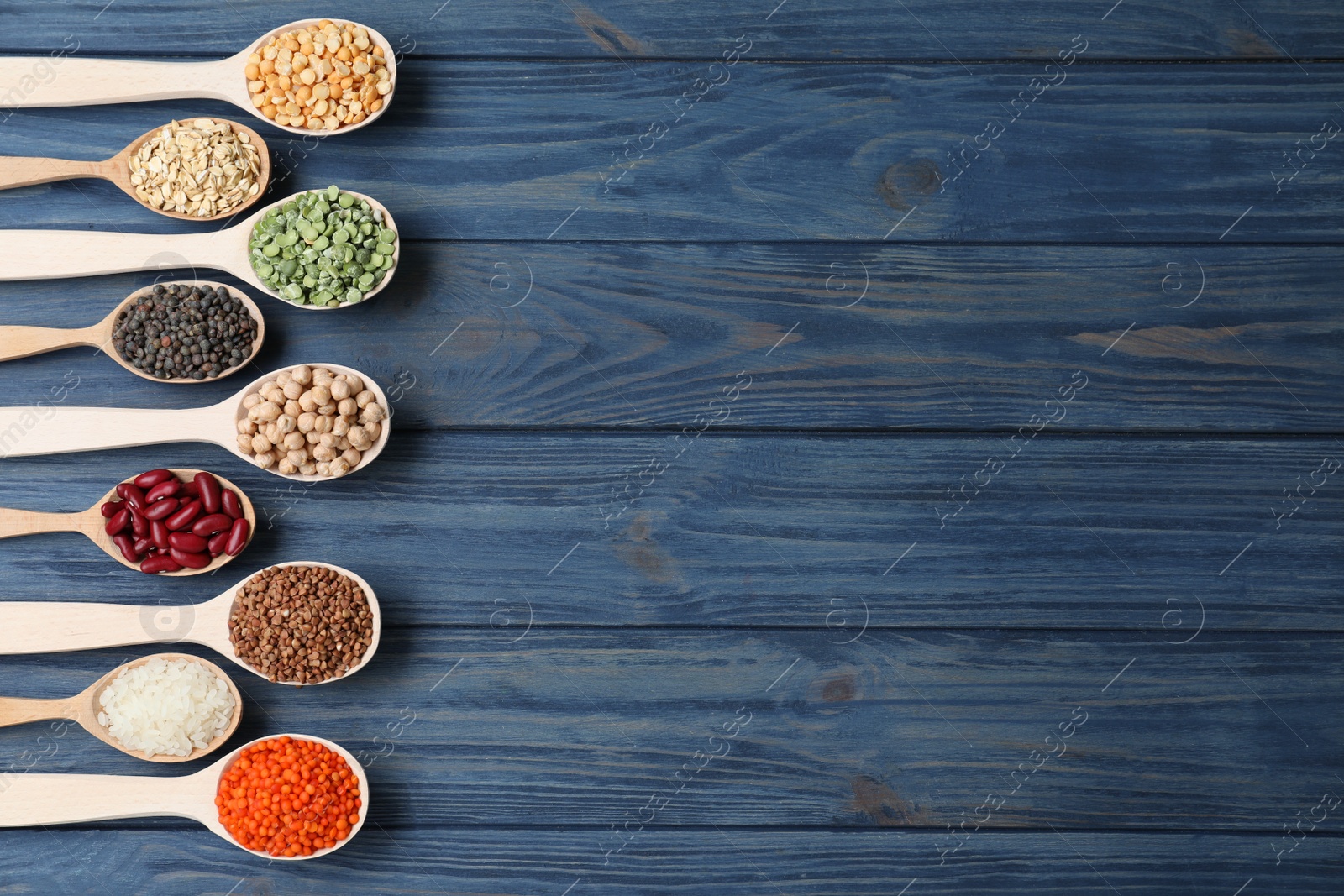 Photo of Flat lay composition with different types of legumes and cereals on blue wooden table, space for text. Organic grains