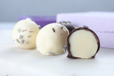 Photo of Delicious chocolate candies on white table, closeup