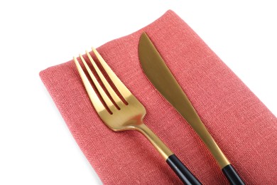 Photo of Coral napkin with golden fork and knife on white background, closeup