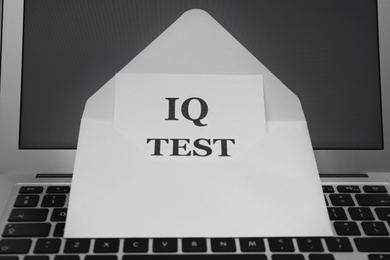 Photo of Paper with words IQ Test in envelope on laptop