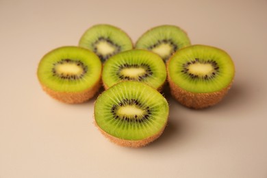 Photo of Halves of fresh kiwis on beige background