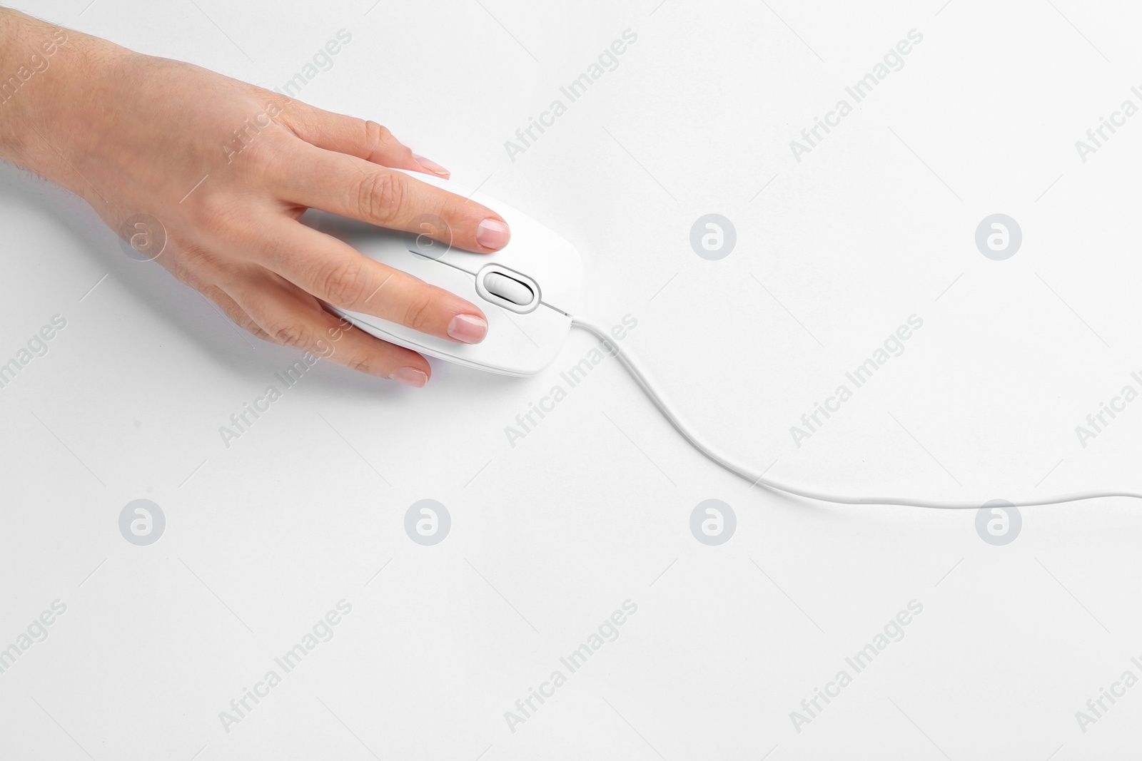 Photo of Woman using modern wired optical mouse on white background, top view