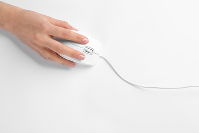 Woman using modern wired optical mouse on white background, top view