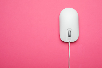 Photo of Wired computer mouse on pink background, top view. Space for text