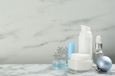 Photo of Beautiful composition with cosmetic products on white marble table, space for text. Winter care