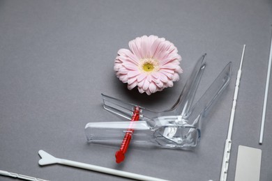 Many gynecological tools and gerbera flower on grey background. Space for text