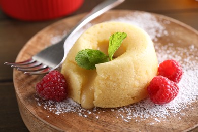 Photo of Tasty vanilla fondant with white chocolate and raspberries on table, closeup