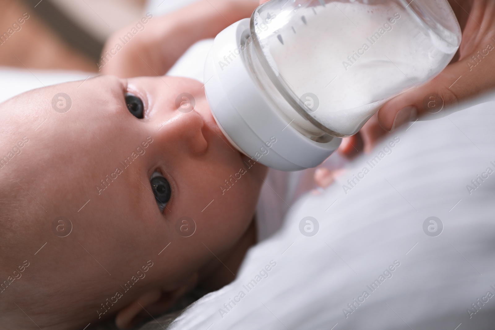 Photo of Mother feeding her little baby from bottle, closeup