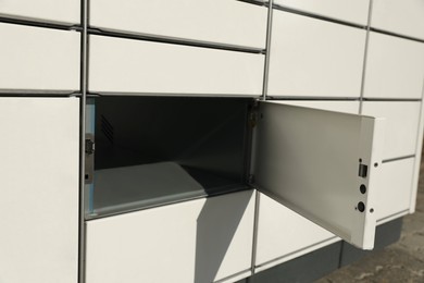 Photo of Modern parcel locker with open box, closeup view