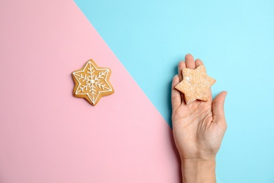 Photo of Woman holding tasty homemade Christmas cookie on color background