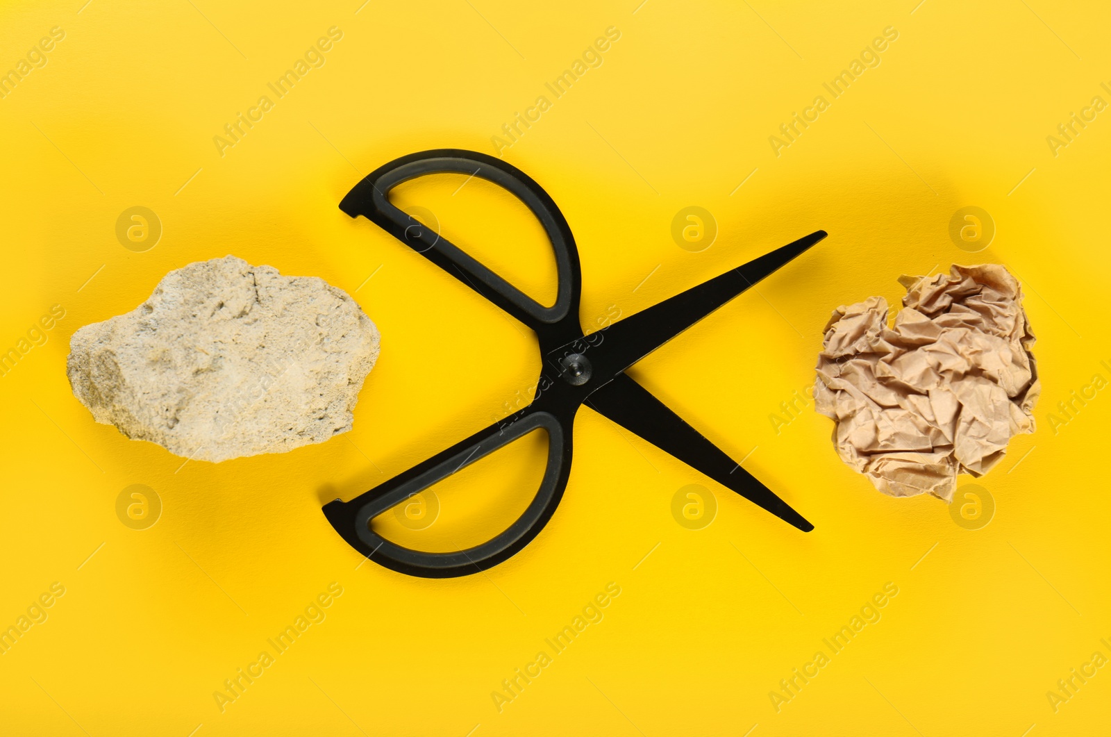 Photo of Flat lay composition with rock, paper and scissors on yellow background