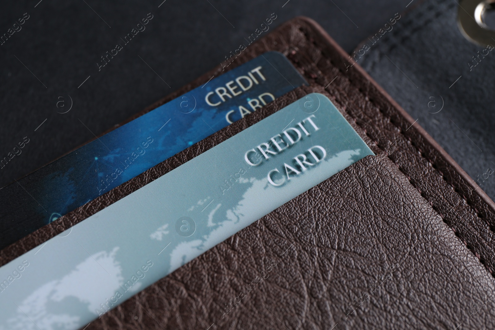 Photo of Credit cards in leather wallet on grey table, closeup