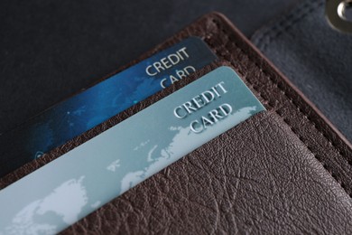 Credit cards in leather wallet on grey table, closeup