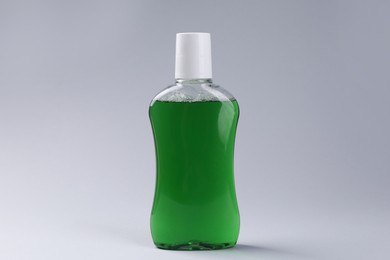 Photo of Fresh mouthwash in bottle on grey background