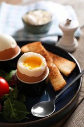 Photo of Delicious breakfast with soft boiled eggs served on wooden table, closeup