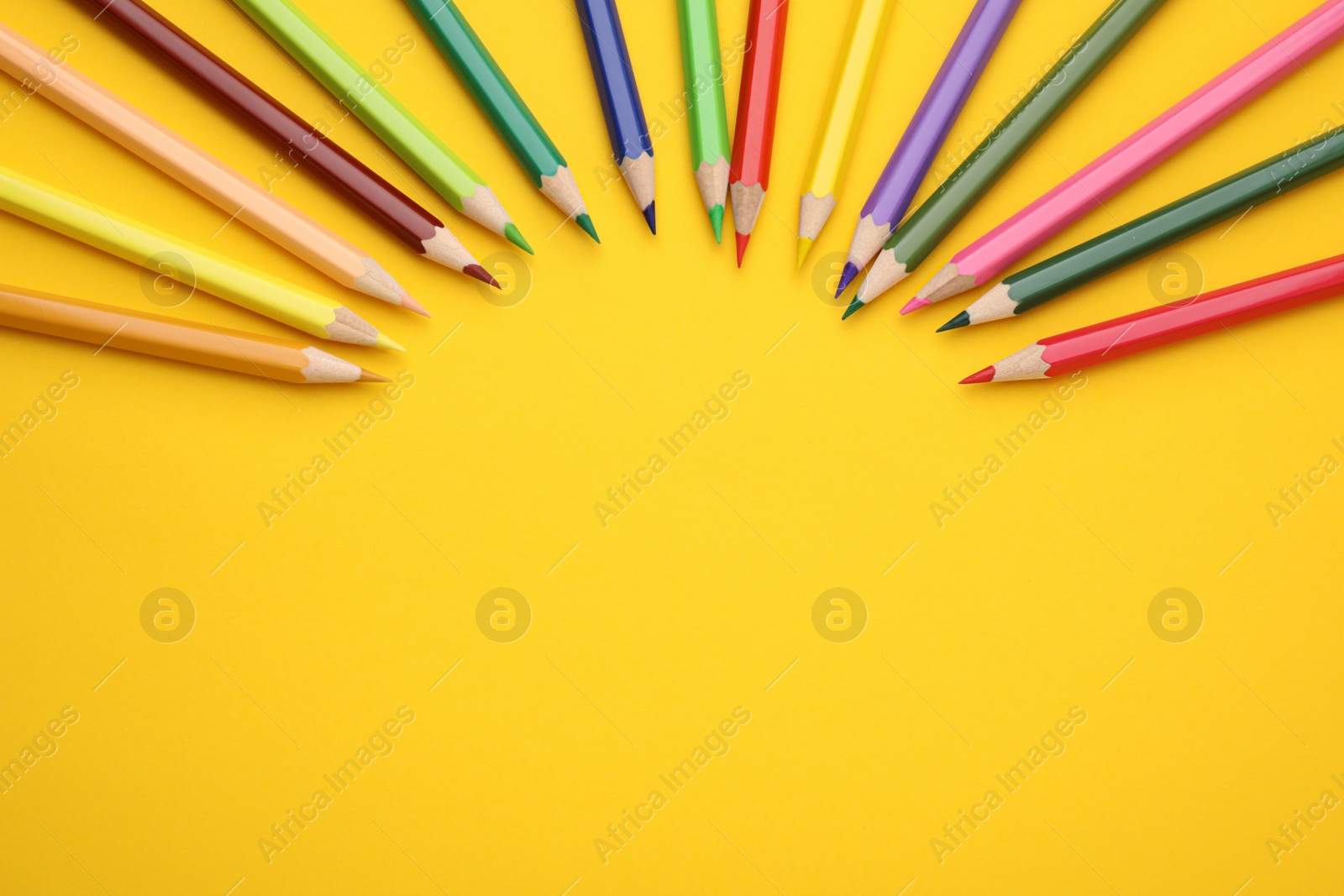 Photo of Colorful wooden pencils on yellow background, flat lay. Space for text