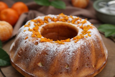 Photo of Homemade yogurt cake with tangerines and powdered sugar on wooden table, closeup