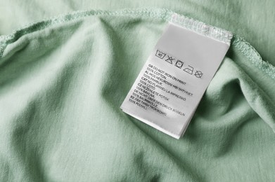 Photo of Clothing label on pale olive garment, closeup