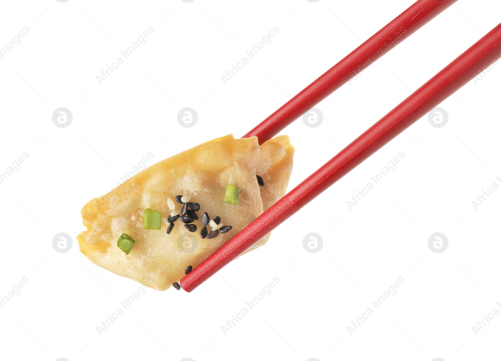 Photo of Chopsticks with delicious gyoza (asian dumpling), onion and sesame isolated on white