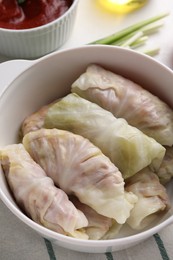 Photo of Uncooked stuffed cabbage rolls on table, closeup
