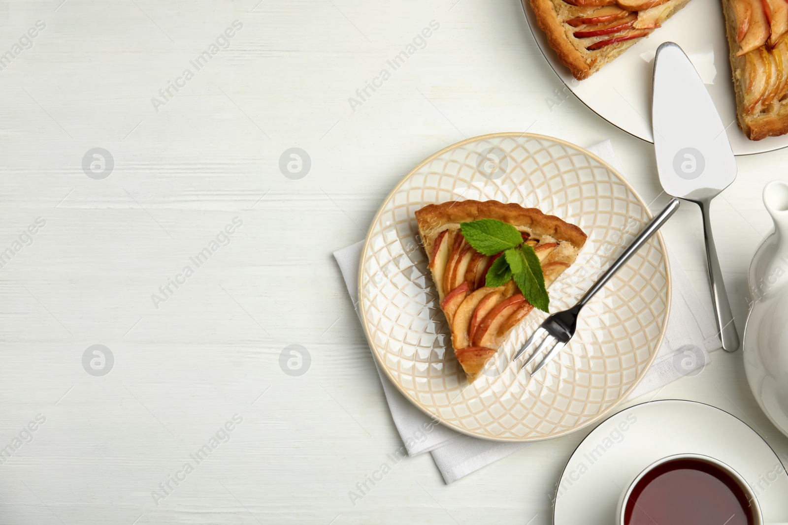 Photo of Delicious apple pie served on white wooden table, flat lay. Space for text