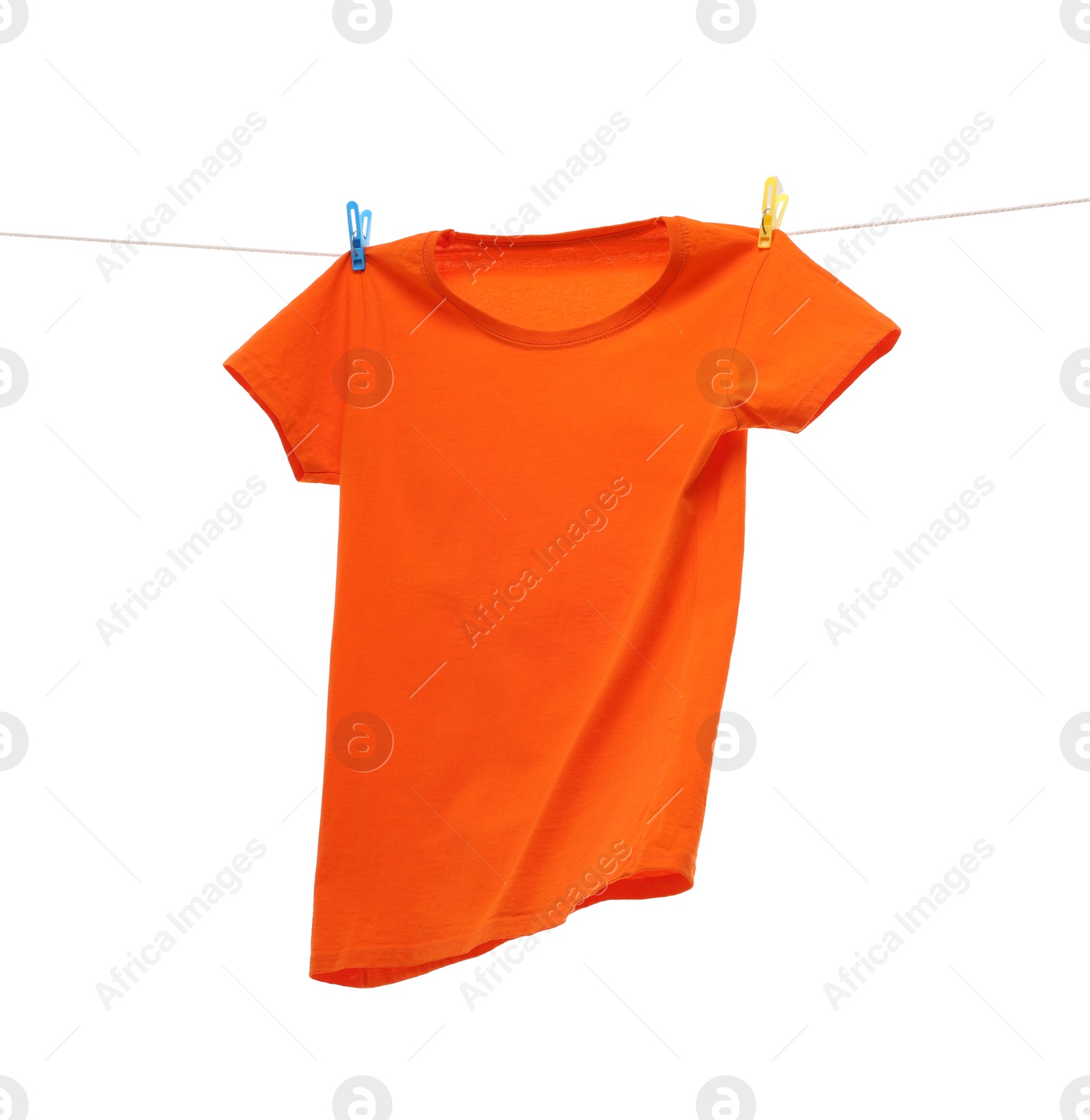 Photo of One orange t-shirt drying on washing line isolated on white