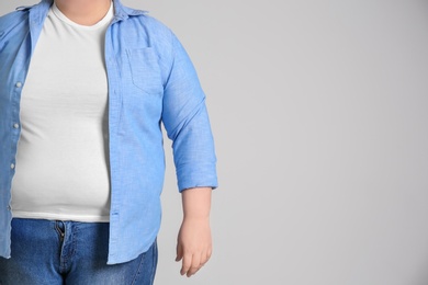 Overweight woman on light background