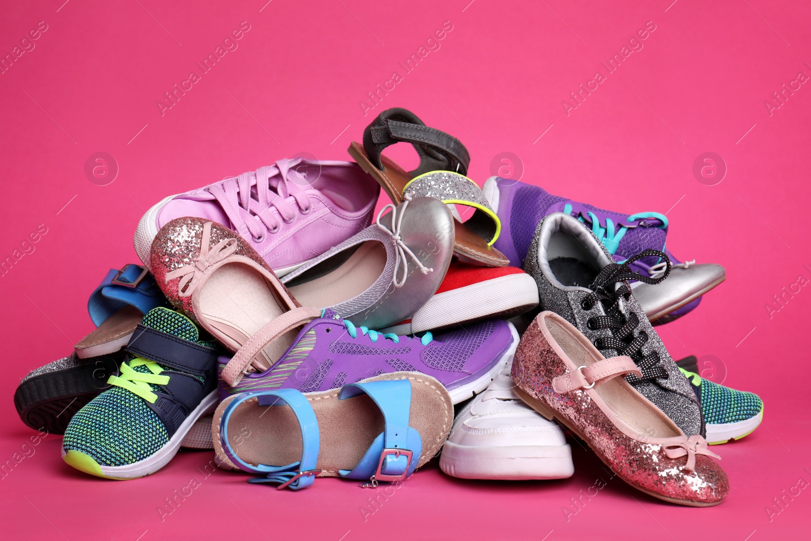 Photo of Heap of different shoes on color background