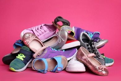 Photo of Heap of different shoes on color background