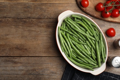 Photo of Flat lay composition with raw green beans on wooden table. Space for text