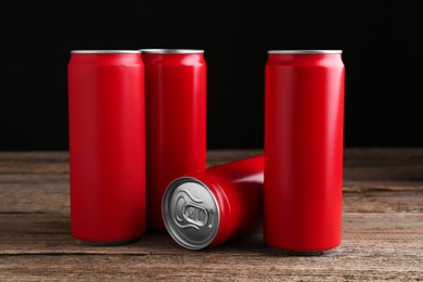 Photo of Energy drinks in red cans on wooden table