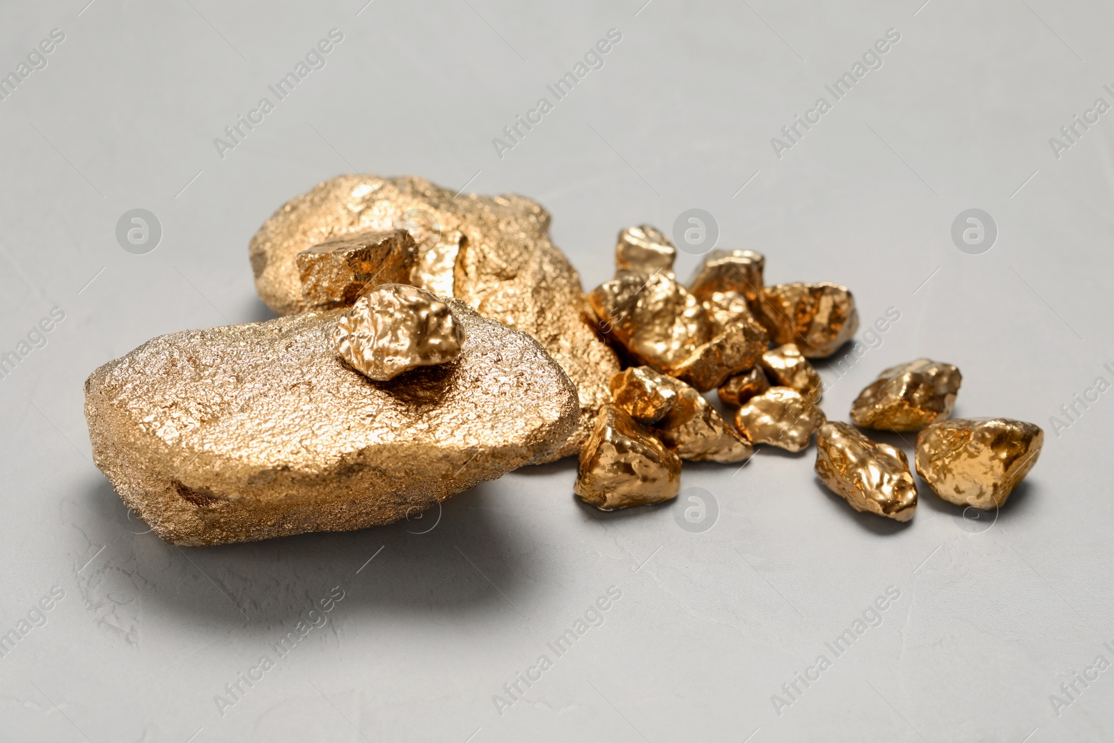 Photo of Pile of gold nuggets on light grey table