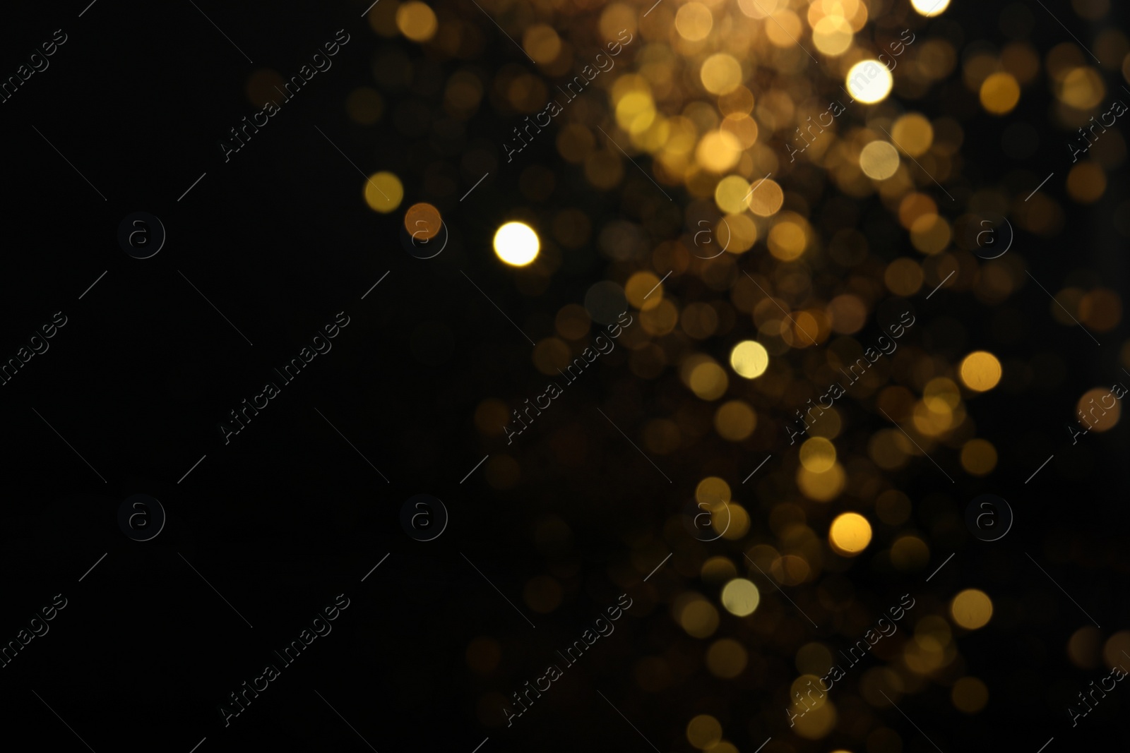 Photo of Blurred view of golden lights on black background. Bokeh effect