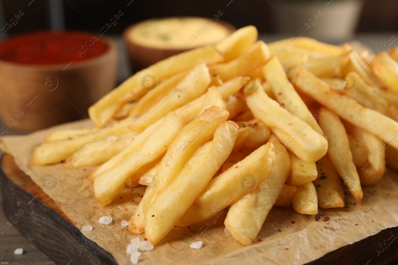 Photo of Delicious french fries on board, closeup view