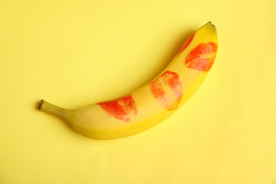 Photo of Fresh banana with red lipstick marks on yellow background. Oral sex concept