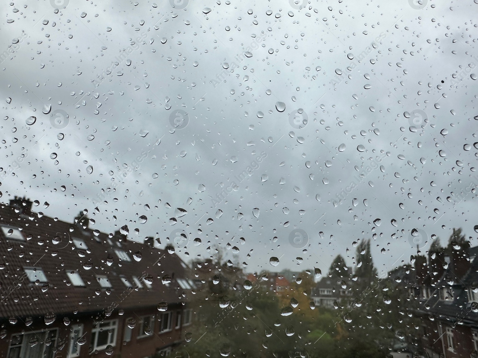 Photo of Window with water droplets on rainy day, closeup