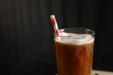 Photo of Refreshing iced coffee with milk in glass against dark gray background, closeup. Space for text