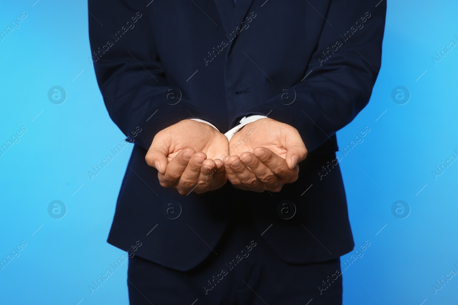 Photo of Businessman holding something on color background, closeup of hands