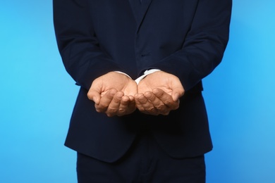 Businessman holding something on color background, closeup of hands